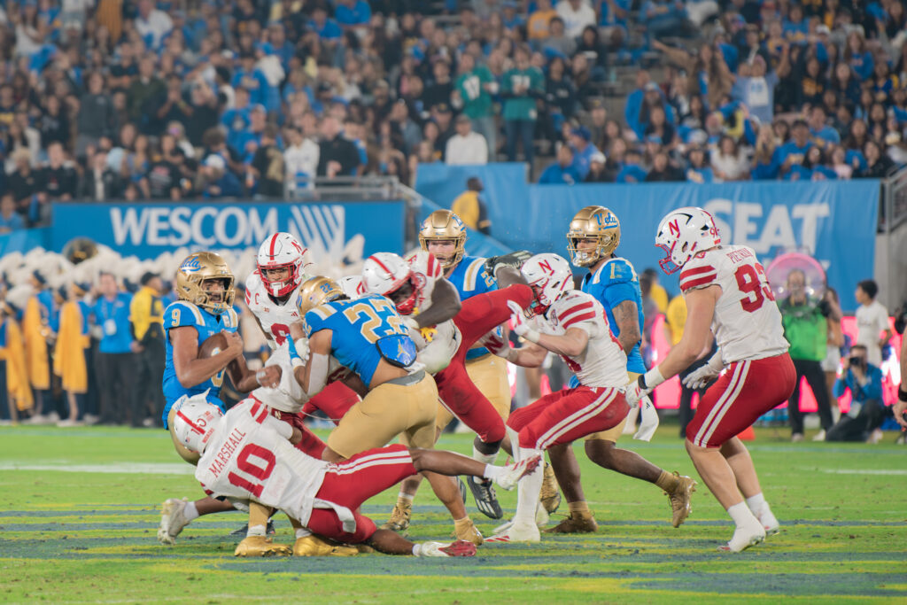 UCLA offense and Nebraska defense scramble together in an attempt to stop UCLA's quarterback Nico Iamaleava from progressing. Nebraska pulled away with three sacks against UCLA's offensive line. Photographed by Luana Caravalho/BruinLife.
