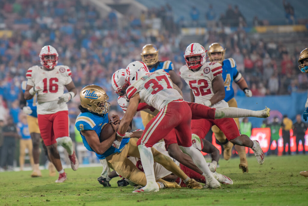 Quarterback , #9 Nico Iamaleava is taken down by Nebraska's defense approaching the endzone. Iamaleava had reached his 15th run of the game. Photographed by Luana Caravalho/BruinLife.