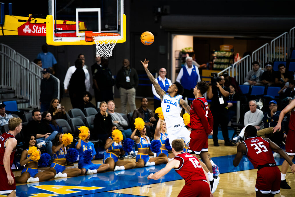 Arm extended, senior Donovan Dent lets the ball fly. The guard brought 21 points home for the Bruins, with Bilodeau, Booker and Perry not far behind. Photographed by Jaclyn Wang/BruinLife.