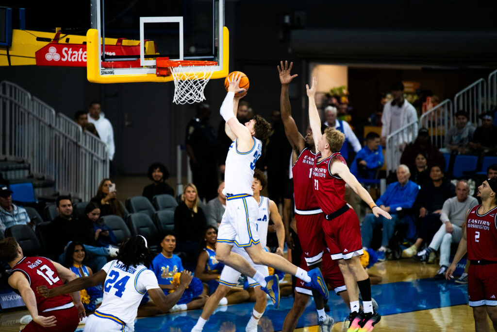Despite pursuit by the Eagles, forward Tyler Bilodeau makes a clean hoop. The senior from Kennewick, Washington scored 19 points for the Bruins in a riveting 80–74 game. Photographed by Jaclyn Wang/BruinLife.