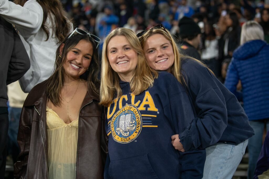 Seniors Keira McNamee, Lucille Johnson, and Abby Brooks watch the UCLA-Washington game from the student section. The senior girls dressed in their best blue and gold to show their support for the Bruins. Photographed by Regan Rhodes/BruinLife.
