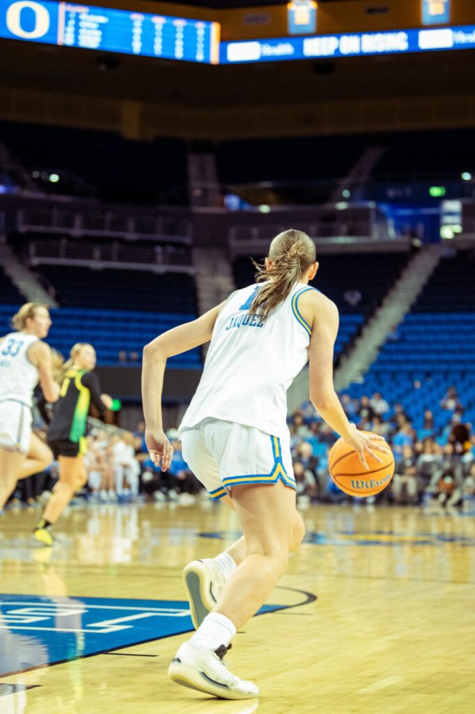 Guard Gabriela Jacquez dribbles the ball as she runs towards the hoop. Once she made it on the opponents side she passed the ball to her teammate who scored.