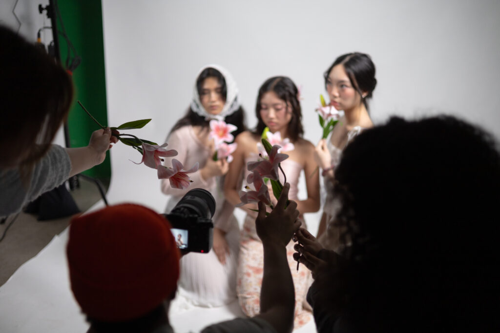 Other members at the shoot assist the photographer in capturing a photo with props. Photographed by Sapna Drew/BruinLife.